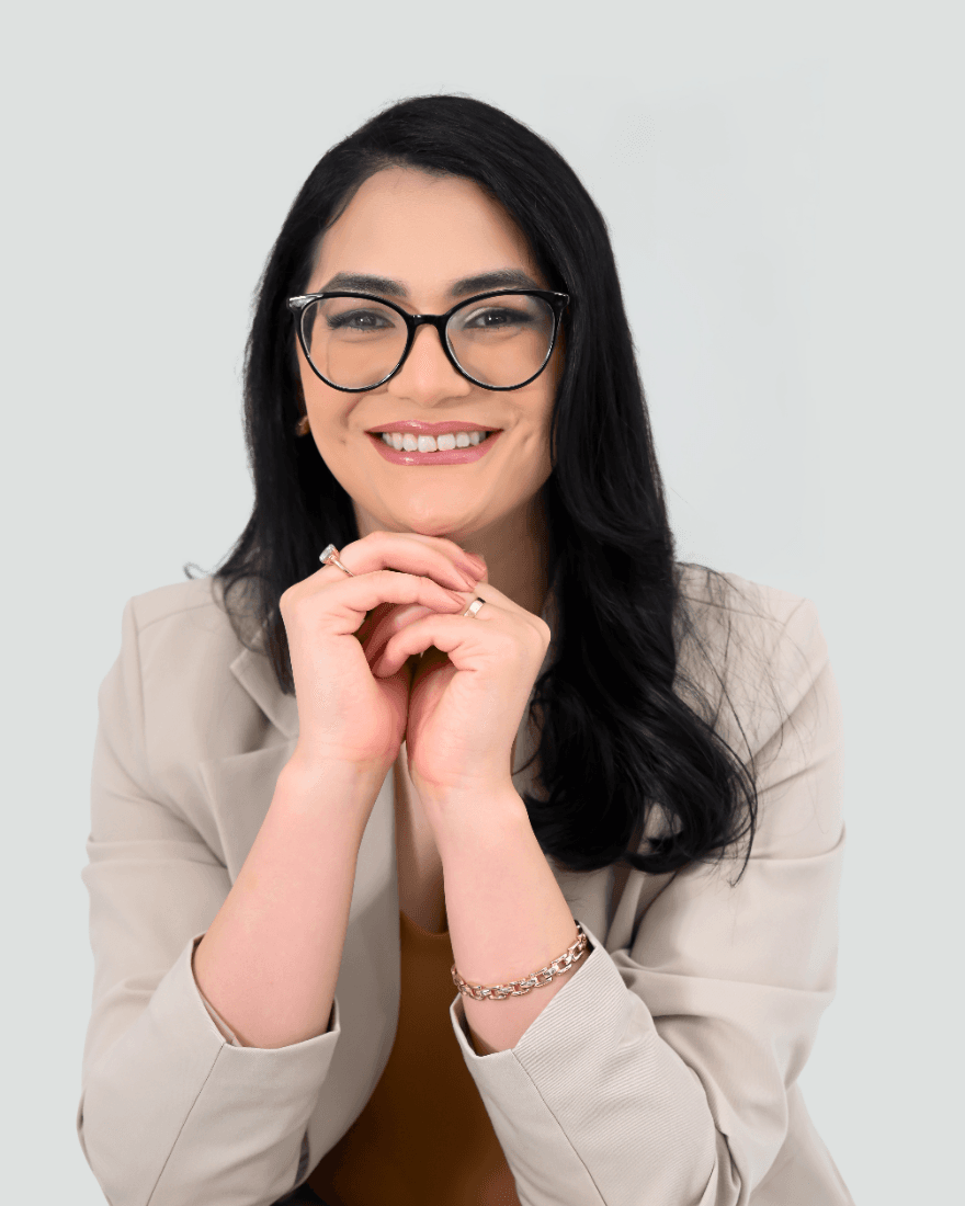 Camila Vieira, advogada, sorrindo, sentada, de terno verde